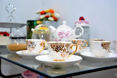 a group of cups and saucers on a glass table at Tambarina Guest House in Mindelo