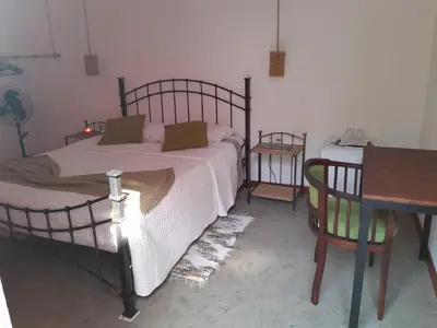 a bedroom with a bed and a wooden table and a tableablish at Kasa Wahnon in Pombas