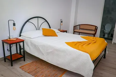 a bedroom with a bed with an orange blanket on it at Kasa Wahnon in Pombas