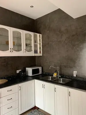 a kitchen with white cabinets and a sink and a microwave at Kasa Wahnon in Pombas