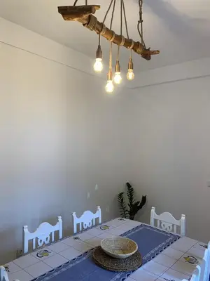 a dining room with a table and a chandelier at Kasa Wahnon in Pombas