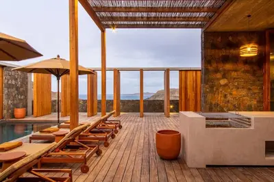 a deck with chairs and a pool with a view at Villa, Vue Mer et Piscine Privée in Mindelo