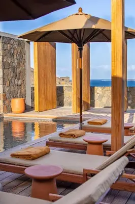 a patio with chairs and an umbrella and a pool at Villa, Vue Mer et Piscine Privée in Mindelo