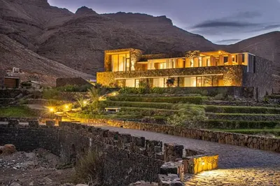 a house in the middle of a mountain at night at Villa, Vue Mer et Piscine Privée in Mindelo