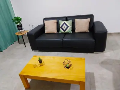 a living room with a black couch and a coffee table at Tity Apartments T2 in Santa Maria