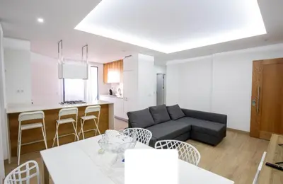 a living room and kitchen with a couch and a table at Rita Apartamento in Mindelo