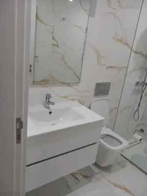 a white bathroom with a sink and a toilet at Rita Apartamento in Mindelo