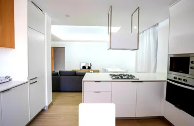 a kitchen with white cabinets and a stove top oven at Rita Apartamento in Mindelo