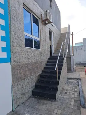 a set of stairs next to a building with a window at Brisa Mar Apartamento in Praia Baixo