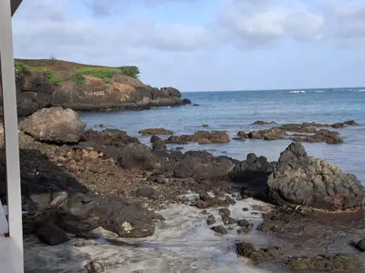 a rocky beach with rocks and the ocean at Brisa Mar Apartamento in Praia Baixo