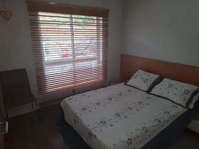 a bedroom with a bed and a window with blinds at Brisa Mar Apartamento in Praia Baixo