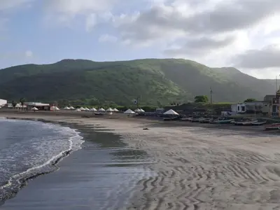 a sandy beach with houses and mountains in the background at Brisa Mar Apartamento in Praia Baixo
