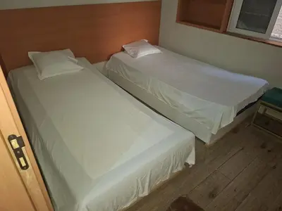 two beds in a small room withermottermott at Brisa Mar Apartamento in Praia Baixo