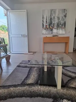 a living room with a glass table and a door at Brisa Mar Apartamento in Praia Baixo