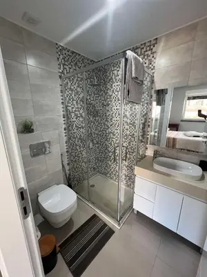 a bathroom with a shower and a toilet and a sink at LAGINHA Apartamento in Mindelo