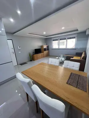 a kitchen and living room with a wooden table and chairs at LAGINHA Apartamento in Mindelo