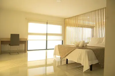 a bedroom with a bed with a table and a window at Apart JC Edificio Victor in Praia