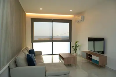 a living room with a couch and a flat screen tv at Apart JC Edificio Victor in Praia