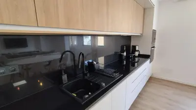 a kitchen with a black counter top and a sink at Sunset in Mindelo