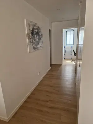 an empty living room with white walls and wood floors at Sunset in Mindelo
