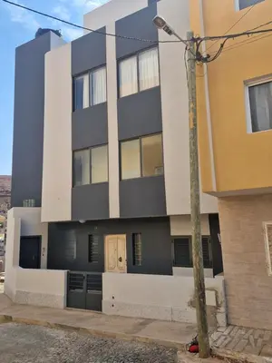 a black and white building with a pole at Sunset in Mindelo