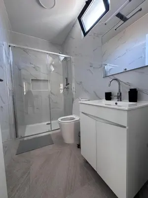 a white bathroom with a shower and a toilet at Sunset in Mindelo