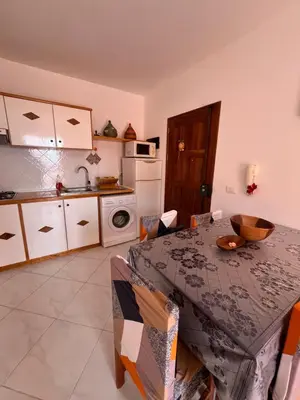 a kitchen with a table with chairs and a kitchen with a sink at Soleado 9 in Santa Maria