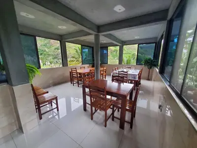 a dining room with tables and chairs and windows at Puntinha d'Djô in Caculi