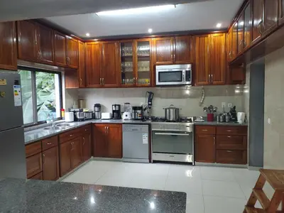 a kitchen with wooden cabinets and stainless steel appliances at Puntinha d'Djô in Caculi