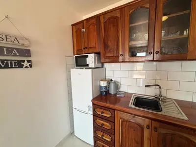 a kitchen with a white refrigerator and wooden cabinets at Blue Ocean Escapes in Santa Maria