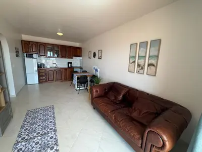 a living room with a brown couch and a kitchen at Blue Ocean Escapes in Santa Maria