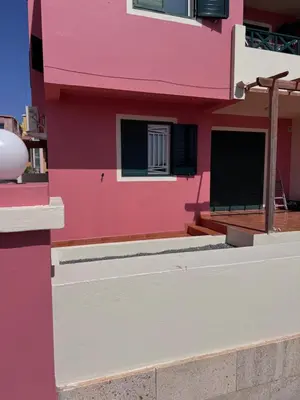 a pink building with black windows and a balcony at Blue Ocean Escapes in Santa Maria