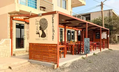 a restaurant with wooden tables and chairs in front of a building at Turtle Apart in Sal Rei