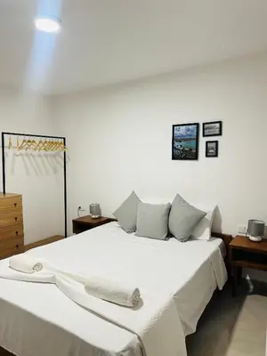 a bedroom with a large bed with white sheets and pillows at Fanon Flat T2 in Mindelo