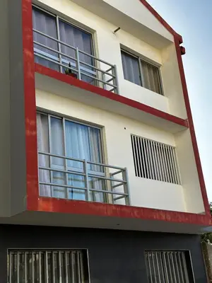 a red and white building with balconies at Fanon Flat T2 in Mindelo