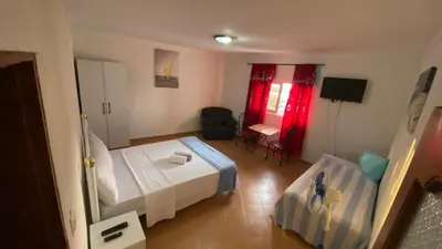 a hotel room with a bed and a chair at Tarrafal Paradise Suite in Tarrafal