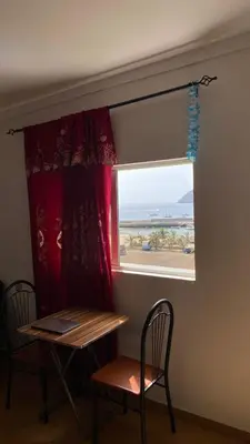 a window with a table and two chairs and a table and a bench at Tarrafal Paradise Suite in Tarrafal