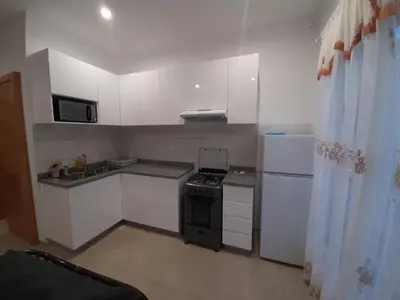 a small kitchen with a stove and a refrigerator at Ap ACVA in Mindelo
