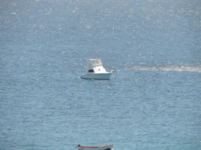 a small boat in the middle of the water at Hotel Halcyone - Ilha do Maio in Calheta Do Maio