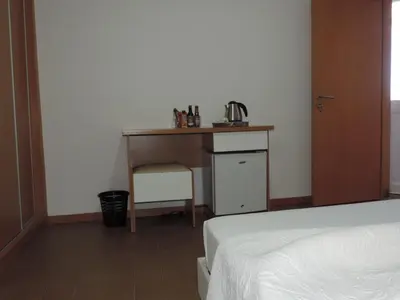 a bedroom with a desk and a bed and a table at Hotel Halcyone - Ilha do Maio in Calheta Do Maio