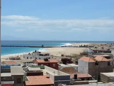 a view of a beach and buildings and the ocean at Hotel Halcyone - Ilha do Maio in Calheta Do Maio