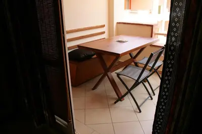a small table and a chair in a room at African Lounge, Moradias Laranja in Prainha