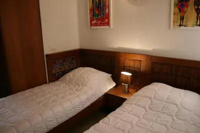 a bedroom with two beds and a lamp on a table at African Lounge, Moradias Laranja in Prainha