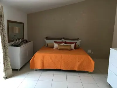 a bedroom with a bed with an orange blanket at Espaço 3M in Praia