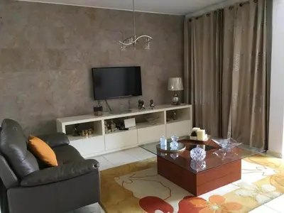 a living room with a television and a couch and a table at Espaço 3M in Praia
