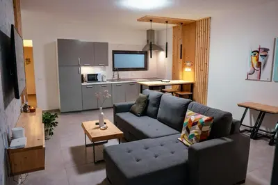 a living room with a couch and a kitchen at Tropical Suite 22 A in Santa Maria