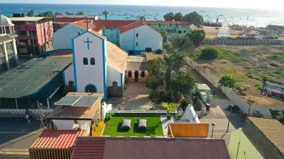 a small church with a cross on top of a town at Tropical Suite 22 B in Santa Maria