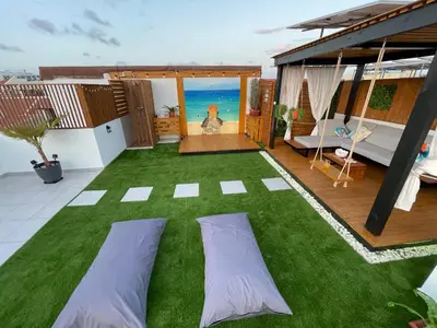 a patio with green grass and a room with the ocean at Tropical Suite 22 B in Santa Maria