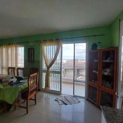 a dining room with a table and a sliding glass door at Oia Mindelo Chambre d'hotes in Mindelo