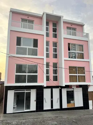 a pink building with white doors and windows at Oásis de retour in Ponta do Sol
